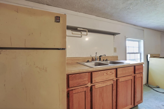 156 E Postal Ave, Newark, OH 43055 - kitchen with freestanding refrigerator, a textured ceiling, light countertops, light carpet, and brown cabinets