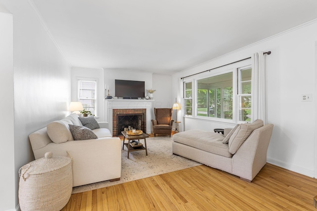 2222 Harwitch Rd, Columbus, OH 43221 - living room featuring crown molding, light wood-style floors, plenty of natural light, and a brick fireplace