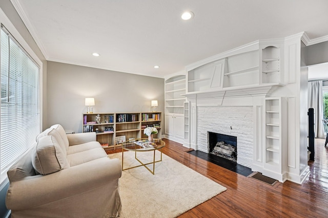 2361 Middlesex Rd, Upper Arlington, OH 43220 - living area with wood finished floors, a stone fireplace, recessed lighting, crown molding, and built in features