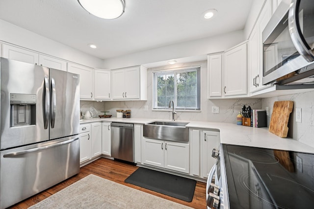 2361 Middlesex Rd, Upper Arlington, OH 43220 - kitchen with appliances with stainless steel finishes, white cabinets, decorative backsplash, dark wood-type flooring, and recessed lighting