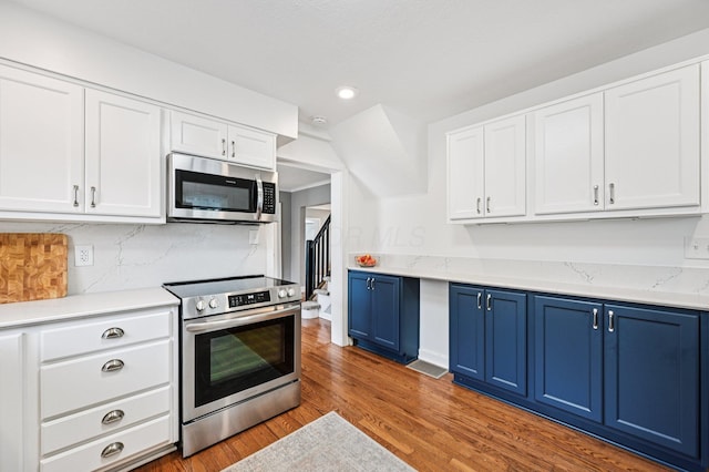 2361 Middlesex Rd, Upper Arlington, OH 43220 - kitchen with appliances with stainless steel finishes, blue cabinetry, recessed lighting, wood finished floors, and backsplash