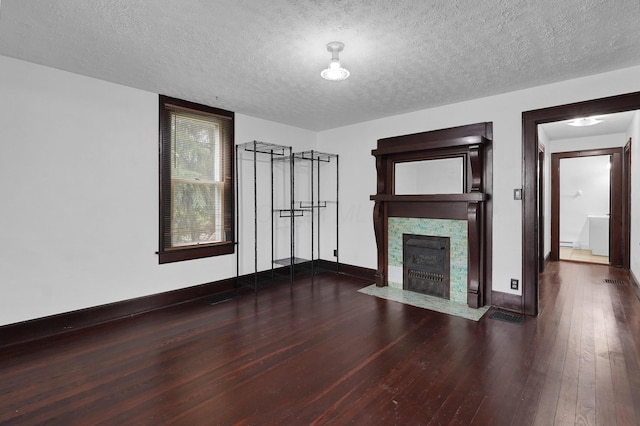 629 E Chestnut St, Lancaster, OH 43130 - unfurnished living room featuring wood-type flooring, a fireplace with flush hearth, a textured ceiling, and baseboard heating