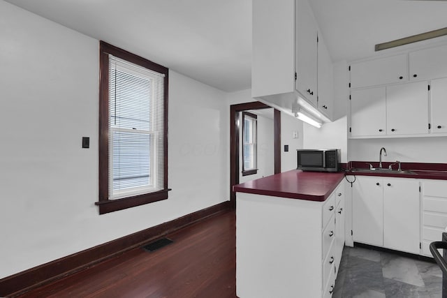 629 E Chestnut St, Lancaster, OH 43130 - kitchen featuring dark countertops, white cabinetry, a peninsula, and dark wood-style flooring