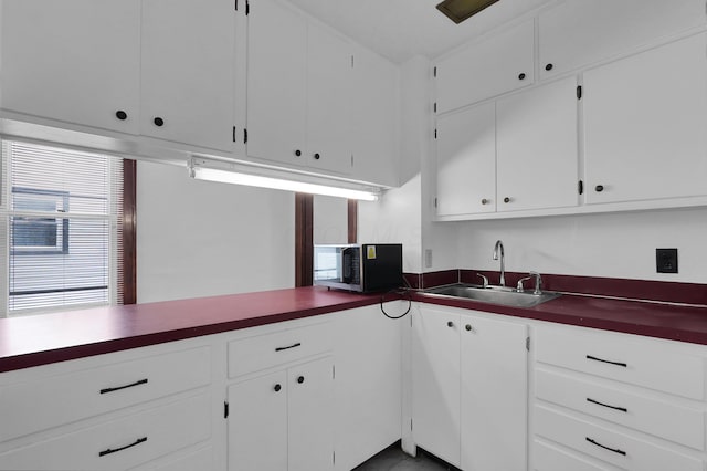 629 E Chestnut St, Lancaster, OH 43130 - kitchen with stainless steel microwave, dark countertops, and white cabinetry