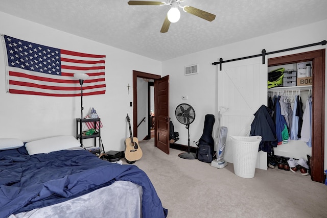 629 E Chestnut St, Lancaster, OH 43130 - carpeted bedroom featuring a barn door, a textured ceiling, a closet, and ceiling fan