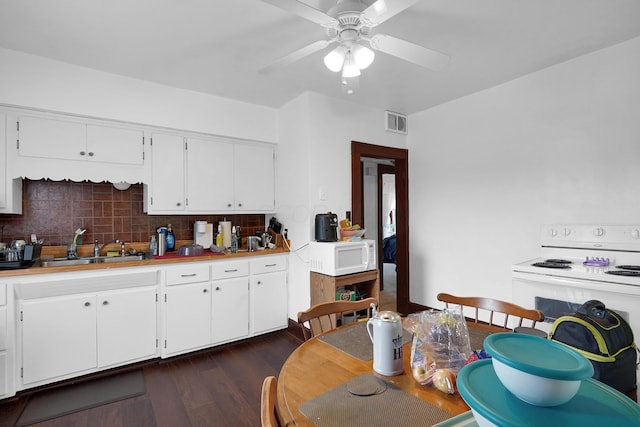629 E Chestnut St, Lancaster, OH 43130 - kitchen featuring white appliances, decorative backsplash, dark wood finished floors, ceiling fan, and white cabinetry