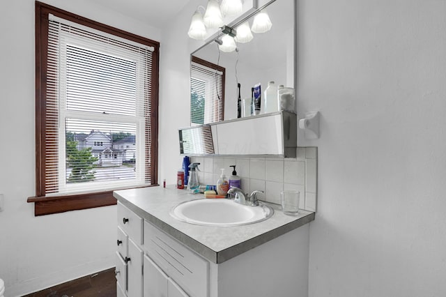 629 E Chestnut St, Lancaster, OH 43130 - bathroom featuring decorative backsplash, vanity, healthy amount of natural light, and wood finished floors