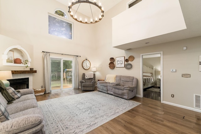 4867 Fosterson Dr, Lockbourne, OH 43137 - living area featuring a chandelier, wood finished floors, a tiled fireplace, and a high ceiling