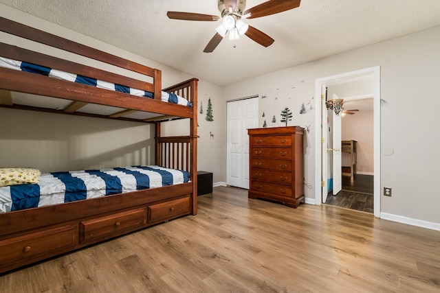 4867 Fosterson Dr, Lockbourne, OH 43137 - bedroom with light wood-type flooring, a closet, a textured ceiling, and a ceiling fan