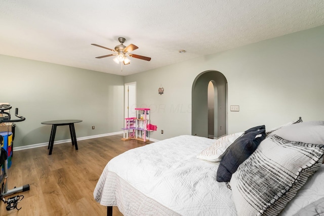 4867 Fosterson Dr, Lockbourne, OH 43137 - bedroom with arched walkways, wood finished floors, a ceiling fan, and a textured ceiling