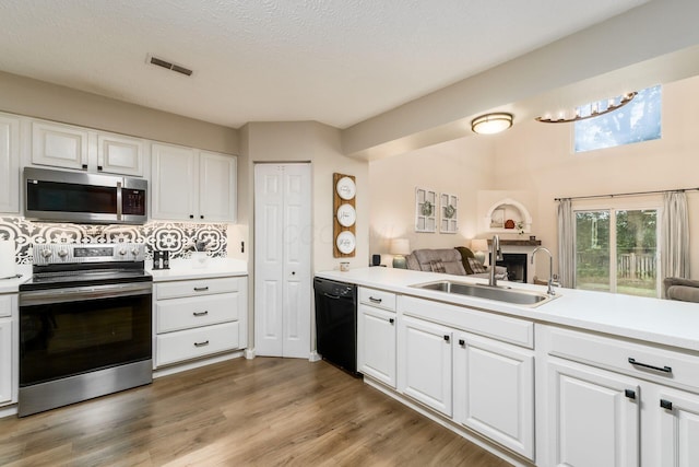 4867 Fosterson Dr, Lockbourne, OH 43137 - kitchen featuring appliances with stainless steel finishes, light countertops, white cabinetry, and light wood-type flooring