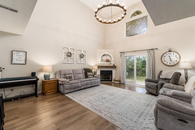 4867 Fosterson Dr, Lockbourne, OH 43137 - living area with a chandelier, wood finished floors, high vaulted ceiling, and a fireplace