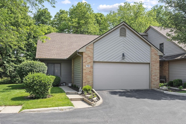 7982 Lewis Ave Unit 21, Dublin, OH 43017 - mid-century modern home featuring a garage, brick siding, driveway, and a front yard