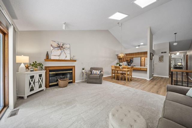 7982 Lewis Ave Unit 21, Dublin, OH 43017 - living room featuring lofted ceiling, a glass covered fireplace, and wood finished floors