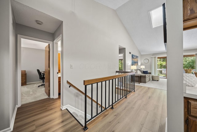 7982 Lewis Ave Unit 21, Dublin, OH 43017 - hall featuring an upstairs landing, light wood-style floors, a skylight, an office area, and high vaulted ceiling