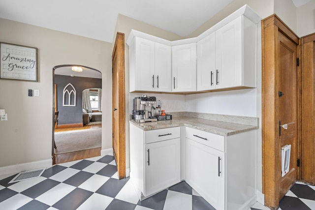 94 W Waterloo St, Canal Winchester, OH 43110 - kitchen with dark flooring, arched walkways, white cabinets, and light stone counters