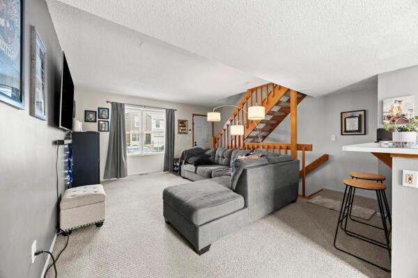 5153 Singleton Dr Unit 44B, Hilliard, OH 43026 - living area with carpet, stairs, and a textured ceiling