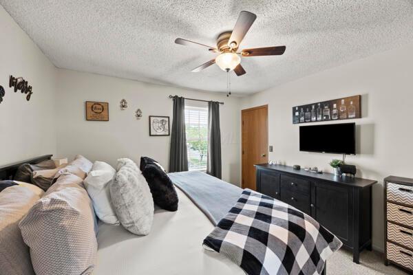 5153 Singleton Dr Unit 44B, Hilliard, OH 43026 - bedroom with a textured ceiling, light carpet, and ceiling fan