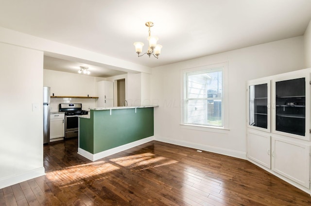 786 Ann St, Columbus, OH 43206 - kitchen featuring stainless steel appliances, a peninsula, a chandelier, dark wood-style floors, and a kitchen bar