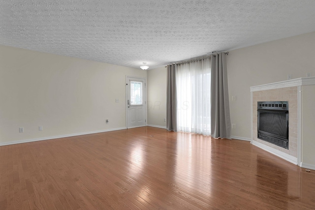 4686 Parrau Dr Unit 64A, Columbus, OH 43228 - unfurnished living room with wood finished floors, a brick fireplace, and a textured ceiling