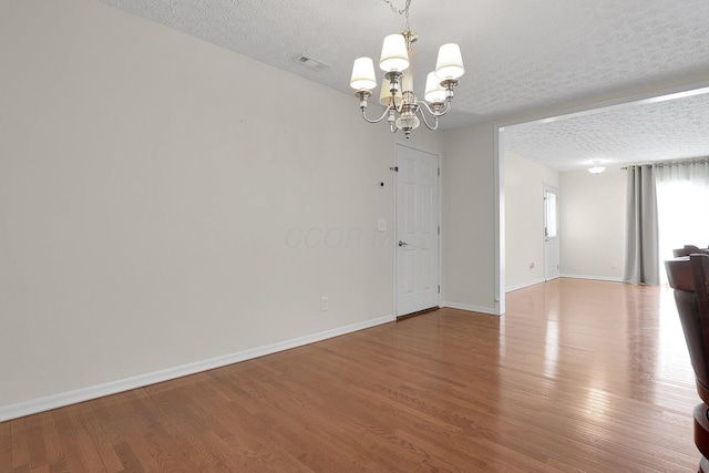 4686 Parrau Dr Unit 64A, Columbus, OH 43228 - spare room with a chandelier, a textured ceiling, and wood finished floors