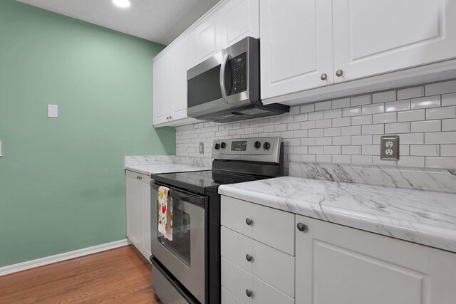 4686 Parrau Dr Unit 64A, Columbus, OH 43228 - kitchen featuring stainless steel appliances, decorative backsplash, white cabinets, light wood-style flooring, and recessed lighting