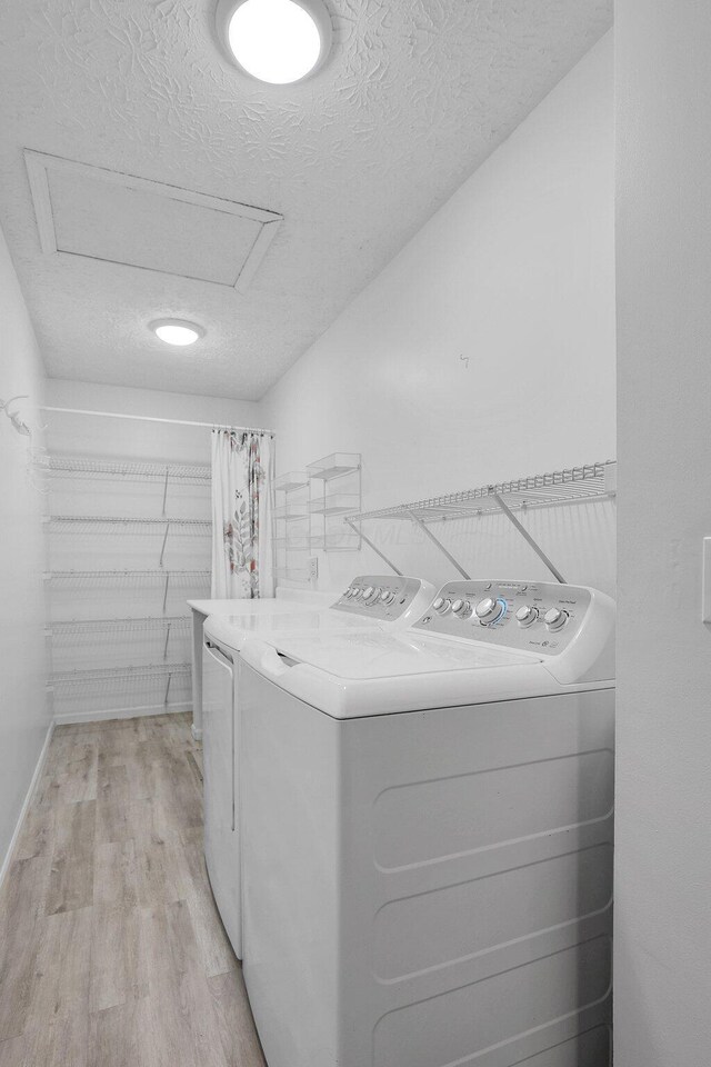 4686 Parrau Dr Unit 64A, Columbus, OH 43228 - laundry area with washing machine and clothes dryer, attic access, a textured ceiling, and light wood-style floors