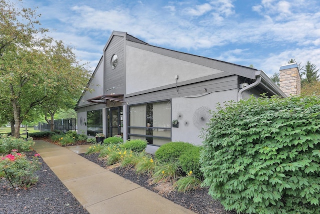 4686 Parrau Dr Unit 64A, Columbus, OH 43228 - view of property exterior featuring stucco siding and a chimney
