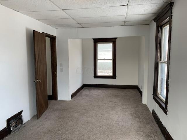 86 Curtis Ave, Newark, OH 43055 - spare room with carpet floors, a paneled ceiling, and plenty of natural light