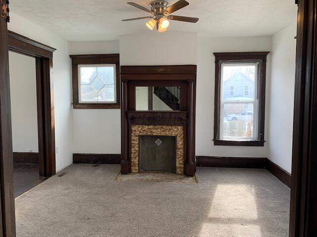 86 Curtis Ave, Newark, OH 43055 - unfurnished living room featuring healthy amount of natural light, carpet floors, ceiling fan, and a premium fireplace