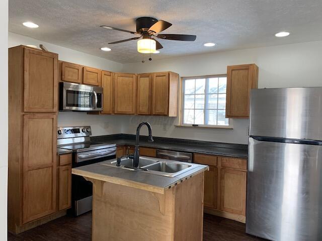 86 Curtis Ave, Newark, OH 43055 - kitchen featuring appliances with stainless steel finishes, ceiling fan, recessed lighting, an island with sink, and dark wood finished floors