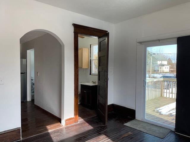 86 Curtis Ave, Newark, OH 43055 - unfurnished room featuring arched walkways, dark wood-style flooring, and healthy amount of natural light