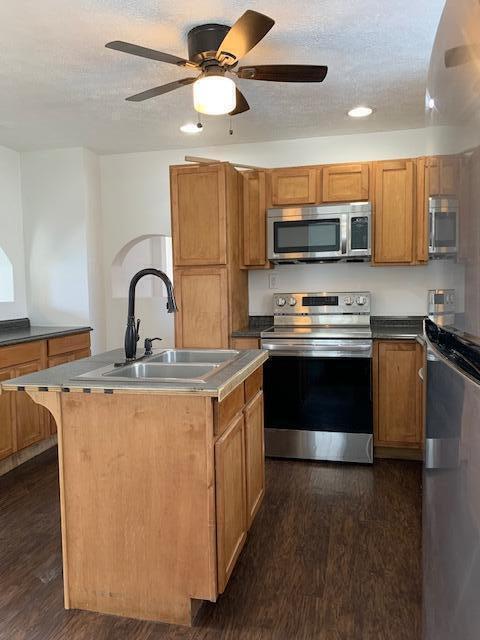 86 Curtis Ave, Newark, OH 43055 - kitchen with appliances with stainless steel finishes, dark wood finished floors, a kitchen island with sink, ceiling fan, and recessed lighting