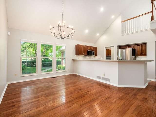 6003 Dunabbey Loop, Dublin, OH 43017 - unfurnished living room featuring a chandelier, wood-type flooring, high vaulted ceiling, and recessed lighting