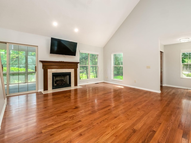 6003 Dunabbey Loop, Dublin, OH 43017 - unfurnished living room featuring high vaulted ceiling, wood finished floors, and a fireplace with flush hearth