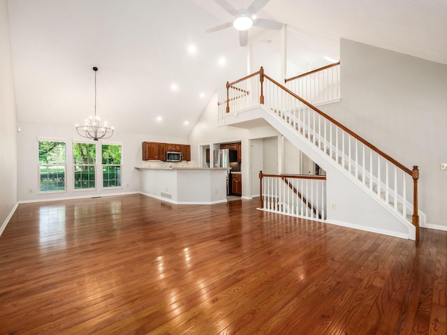 6003 Dunabbey Loop, Dublin, OH 43017 - unfurnished living room featuring high vaulted ceiling, a chandelier, hardwood / wood-style floors, a ceiling fan, and stairway