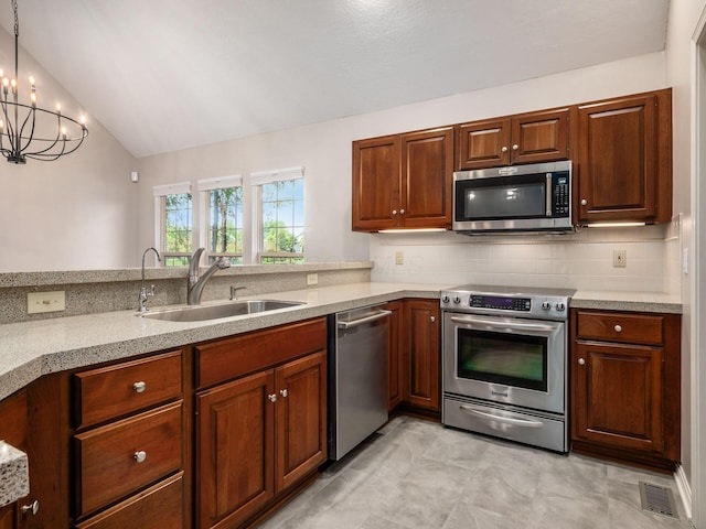 6003 Dunabbey Loop, Dublin, OH 43017 - kitchen with stainless steel appliances, decorative backsplash, vaulted ceiling, a chandelier, and hanging light fixtures