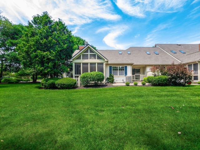 6003 Dunabbey Loop, Dublin, OH 43017 - rear view of house featuring a sunroom, a lawn, a shingled roof, and a chimney