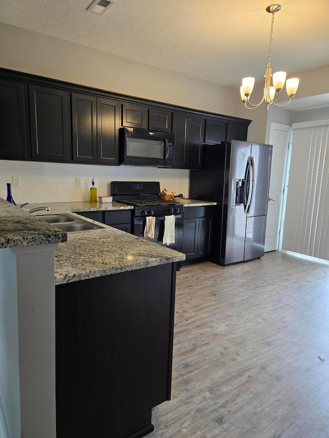 91 Neptune Ave, Newark, OH 43055 - kitchen with black appliances, dark cabinetry, light wood-style flooring, and light stone countertops