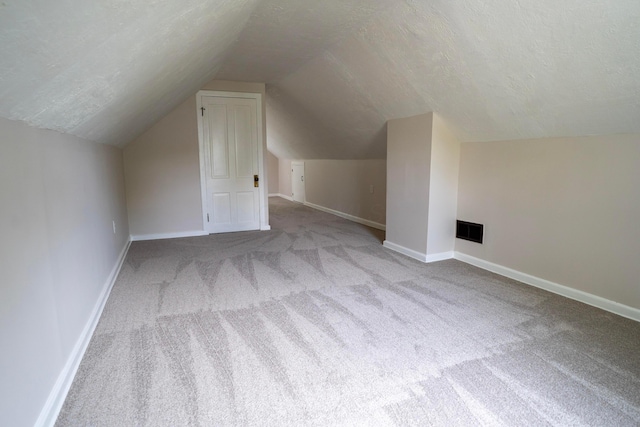 1326 E 19th Ave, Columbus, OH 43211 - additional living space with carpet floors, vaulted ceiling, and a textured ceiling
