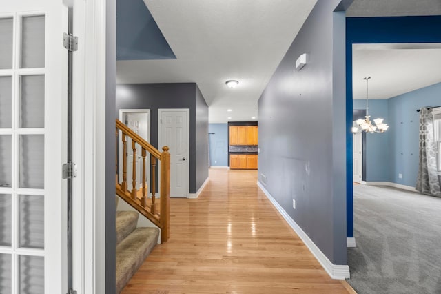 4003 Laurel Valley Dr, Powell, OH 43065 - corridor featuring a chandelier, stairway, and light wood-style flooring
