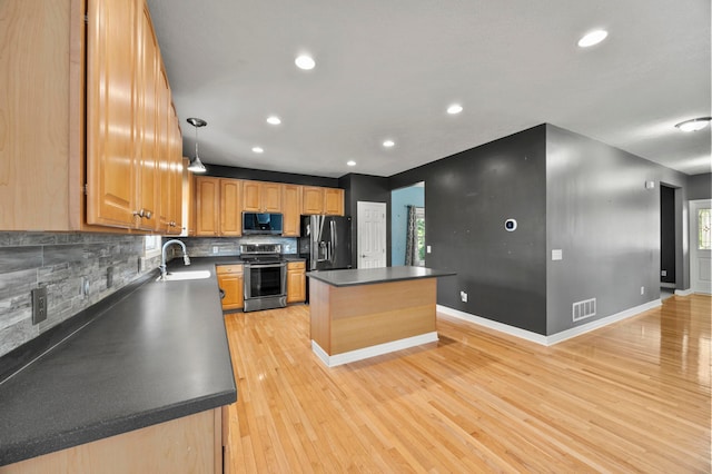 4003 Laurel Valley Dr, Powell, OH 43065 - kitchen with appliances with stainless steel finishes, a kitchen island, dark countertops, light wood finished floors, and tasteful backsplash