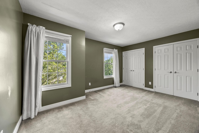 4003 Laurel Valley Dr, Powell, OH 43065 - unfurnished bedroom with two closets, carpet, multiple windows, and a textured ceiling