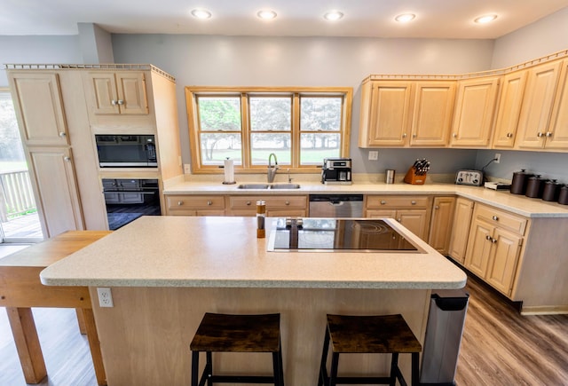 793 Waldo Fulton Rd, Waldo, OH 43356 - kitchen with light brown cabinetry, black appliances, a breakfast bar area, light countertops, and recessed lighting