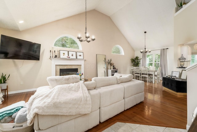 7954 Windrift Pl, Reynoldsburg, OH 43068 - living room featuring a chandelier, high vaulted ceiling, a tiled fireplace, and wood finished floors
