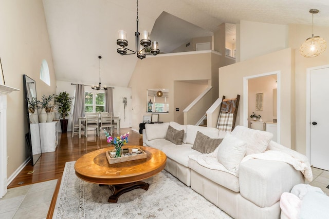 7954 Windrift Pl, Reynoldsburg, OH 43068 - living room featuring a chandelier, high vaulted ceiling, stairs, and light wood-style floors