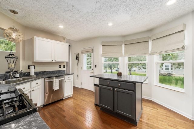 7954 Windrift Pl, Reynoldsburg, OH 43068 - kitchen with dishwasher, black range with gas stovetop, white cabinetry, hardwood / wood-style flooring, and a textured ceiling