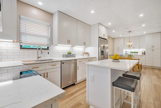 1439 Tall Meadows Dr, Columbus, OH 43223 - kitchen with appliances with stainless steel finishes, a center island, light wood-style floors, a kitchen bar, and white cabinetry