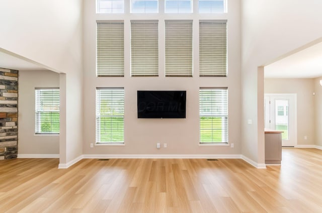 600 Courtright Dr E, Pickerington, OH 43147 - unfurnished living room featuring a towering ceiling, light wood finished floors, and a stone fireplace