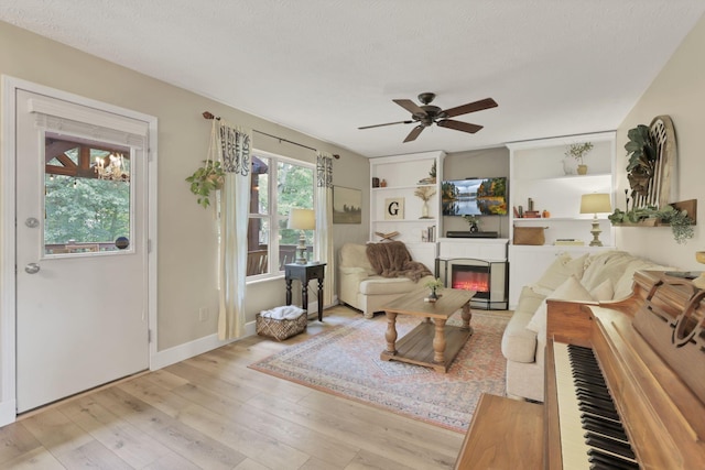 437 Barrington Rdg, Pataskala, OH 43062 - living area with ceiling fan, light wood-style flooring, a glass covered fireplace, and a textured ceiling